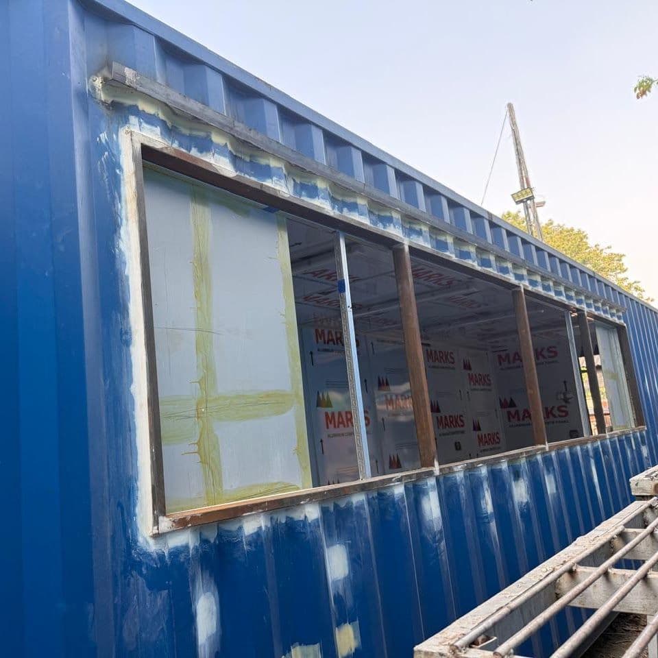 Container 40 ft biru dengan jendela panjang