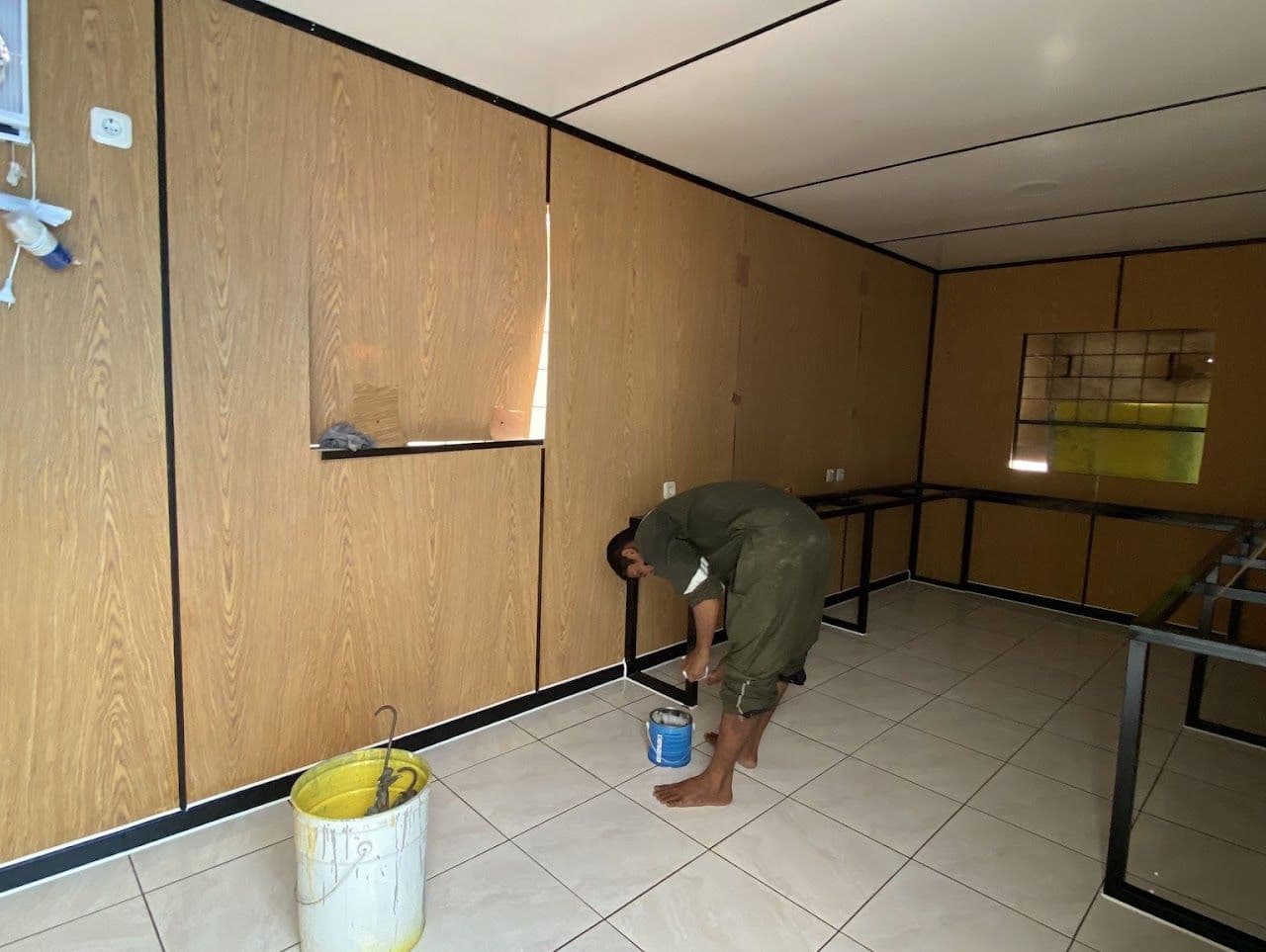 Interior container berdinding kayu dengan rangka meja