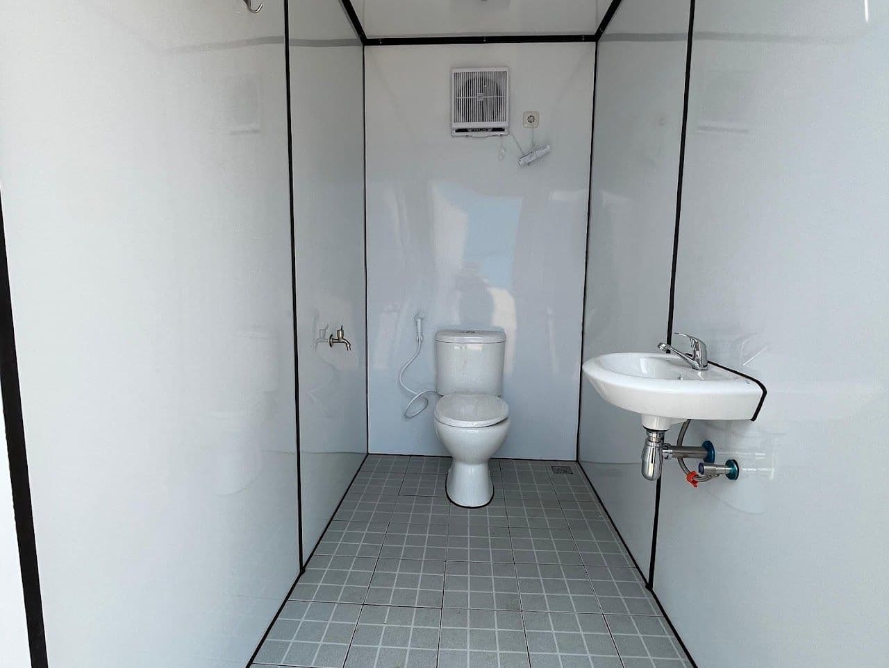 Toilet duduk dan wastafel di dalam container